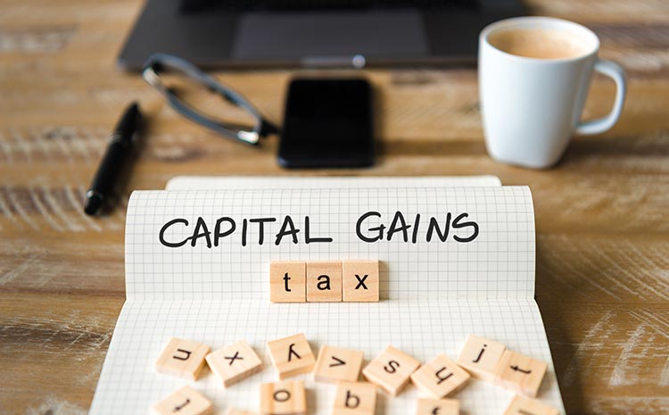 Capital gains written on a piece of paper Plusvalia Tax